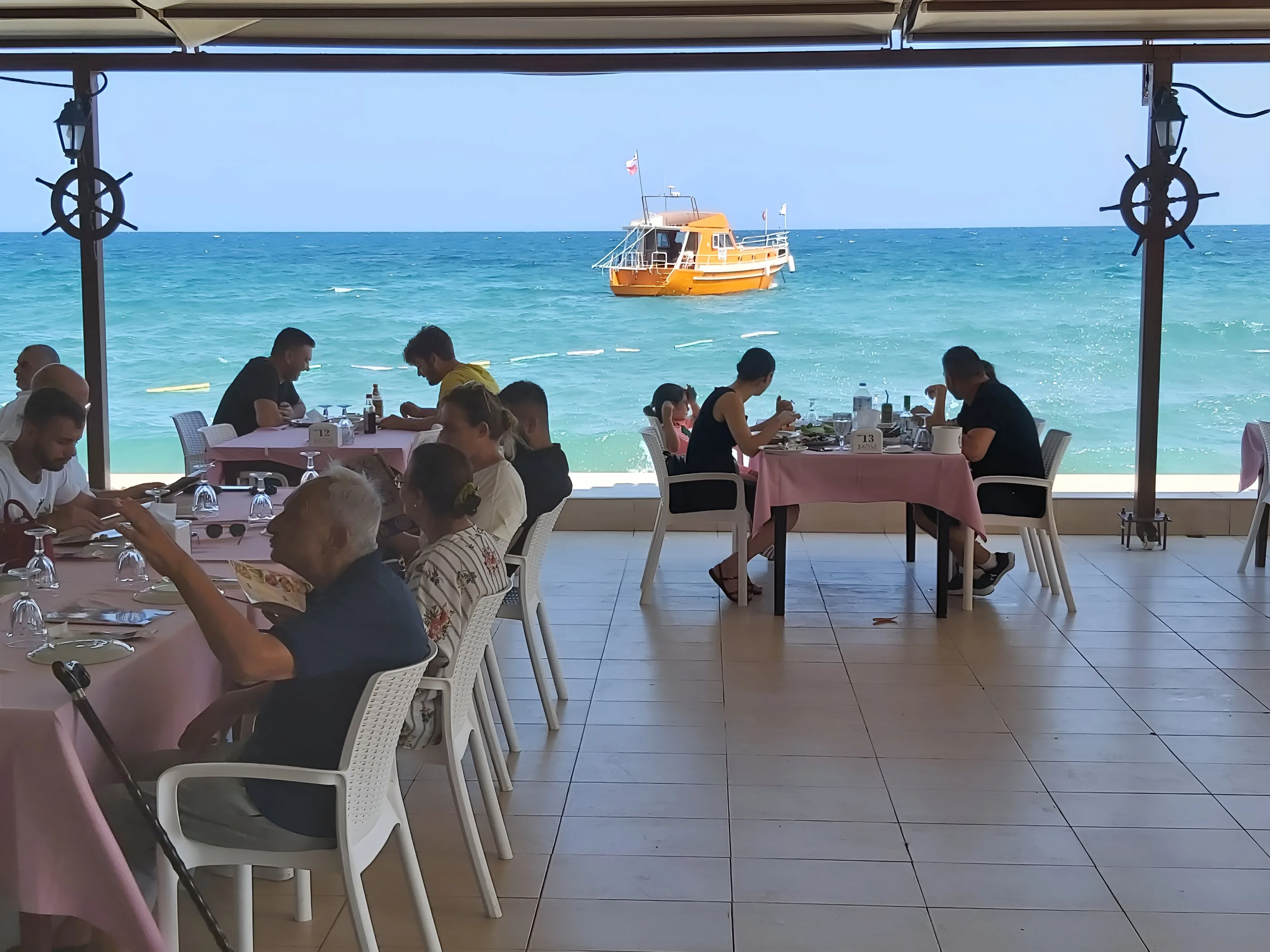 Kıyı Restaurant terrace by the sea with a boat on the water